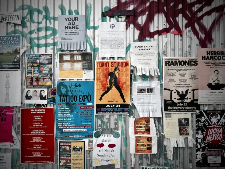 some posters and flyers hanging on a wall