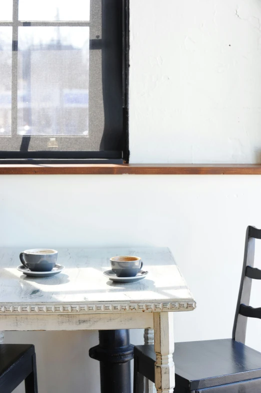 two bowls on a table near a window