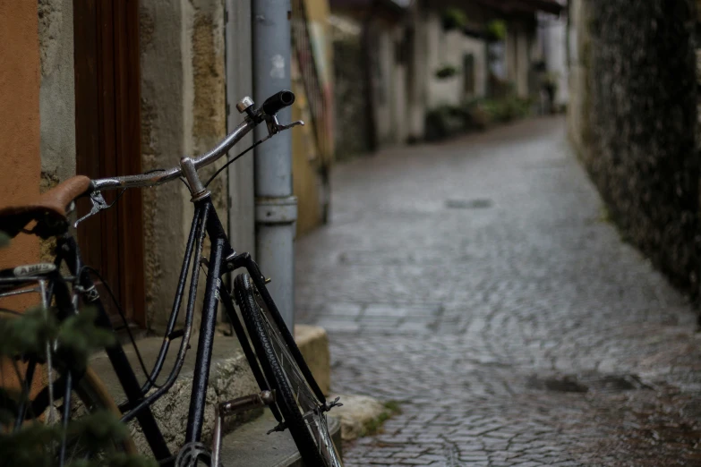 a bike is parked on the side of an old brick street
