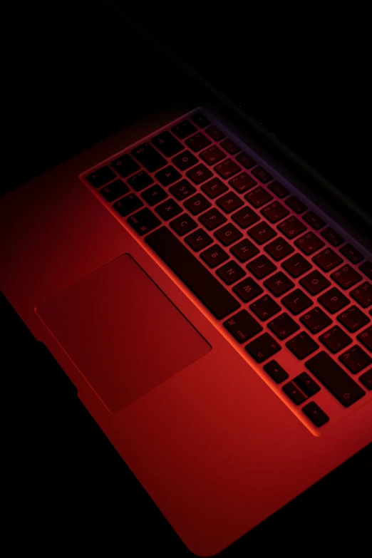 an illuminated laptop computer with red lights in the dark