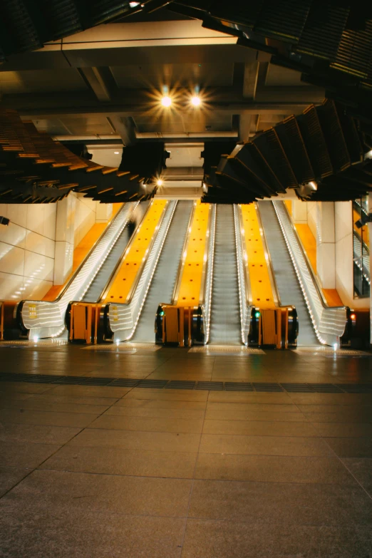 a few yellow empty escalator doors in a building