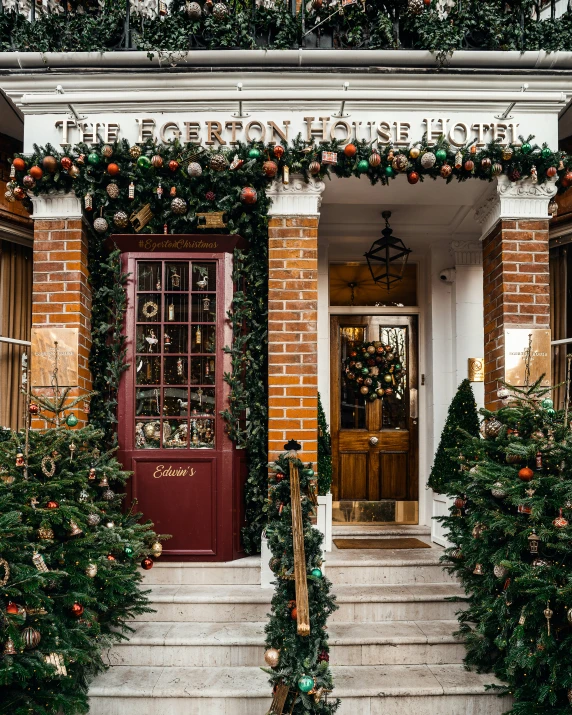 a brick building has flowers, greenery and holiday decorations on the front