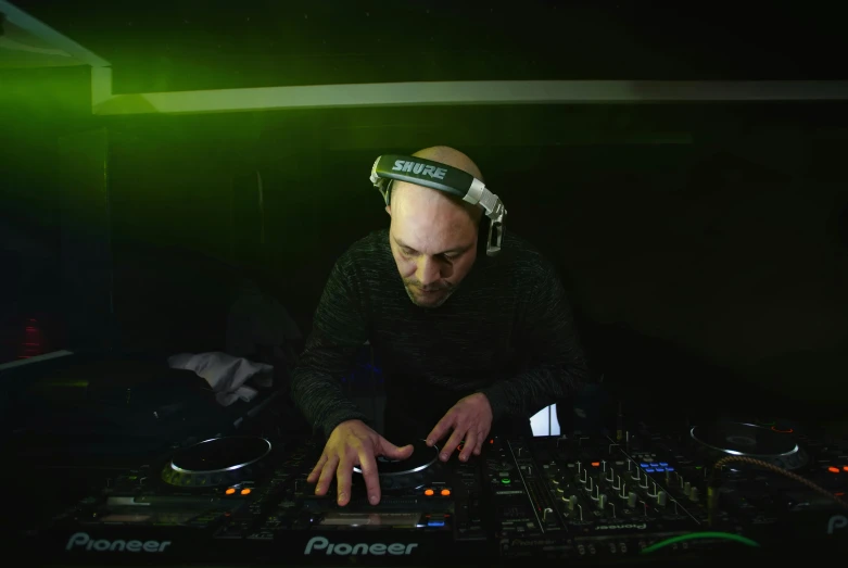 a dj at the mixing desk wearing headphones