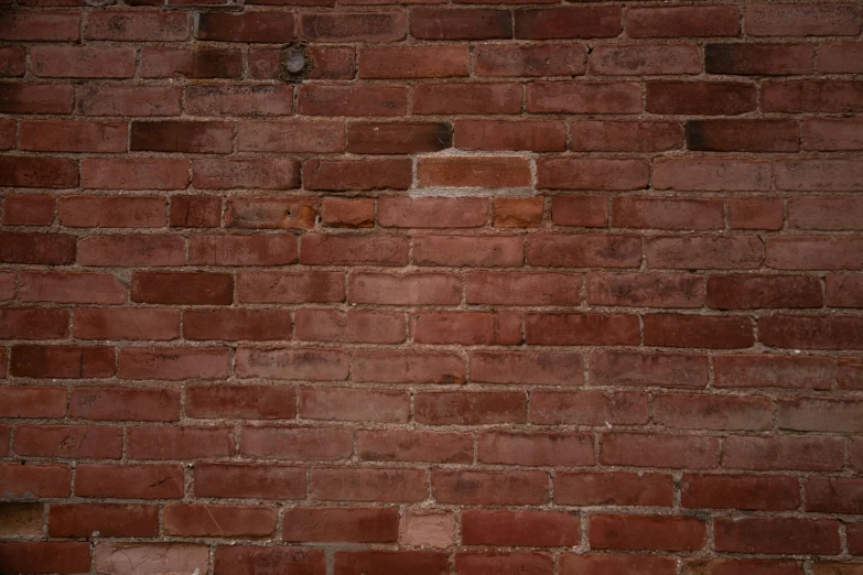 a brick wall with some dirt spots and a white frisbee