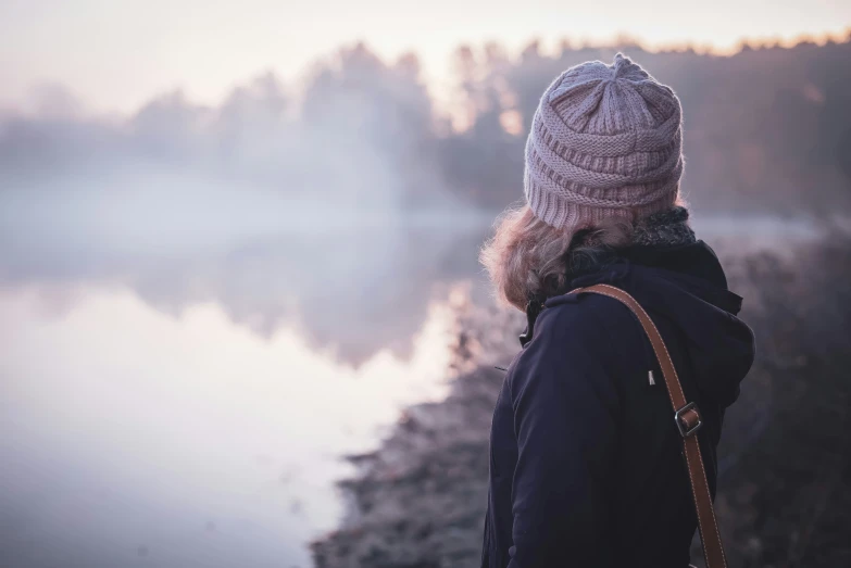 the person with the hat is staring at the water