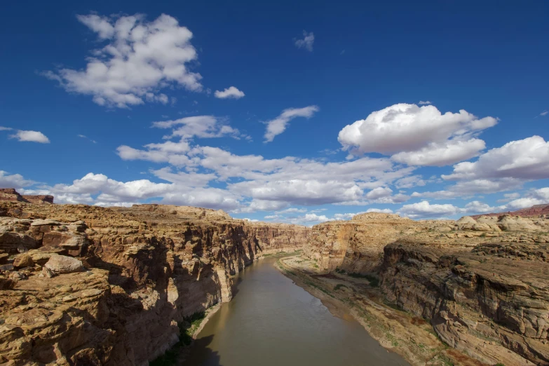 a scenic image of an unpaved river surrounded by cliffs