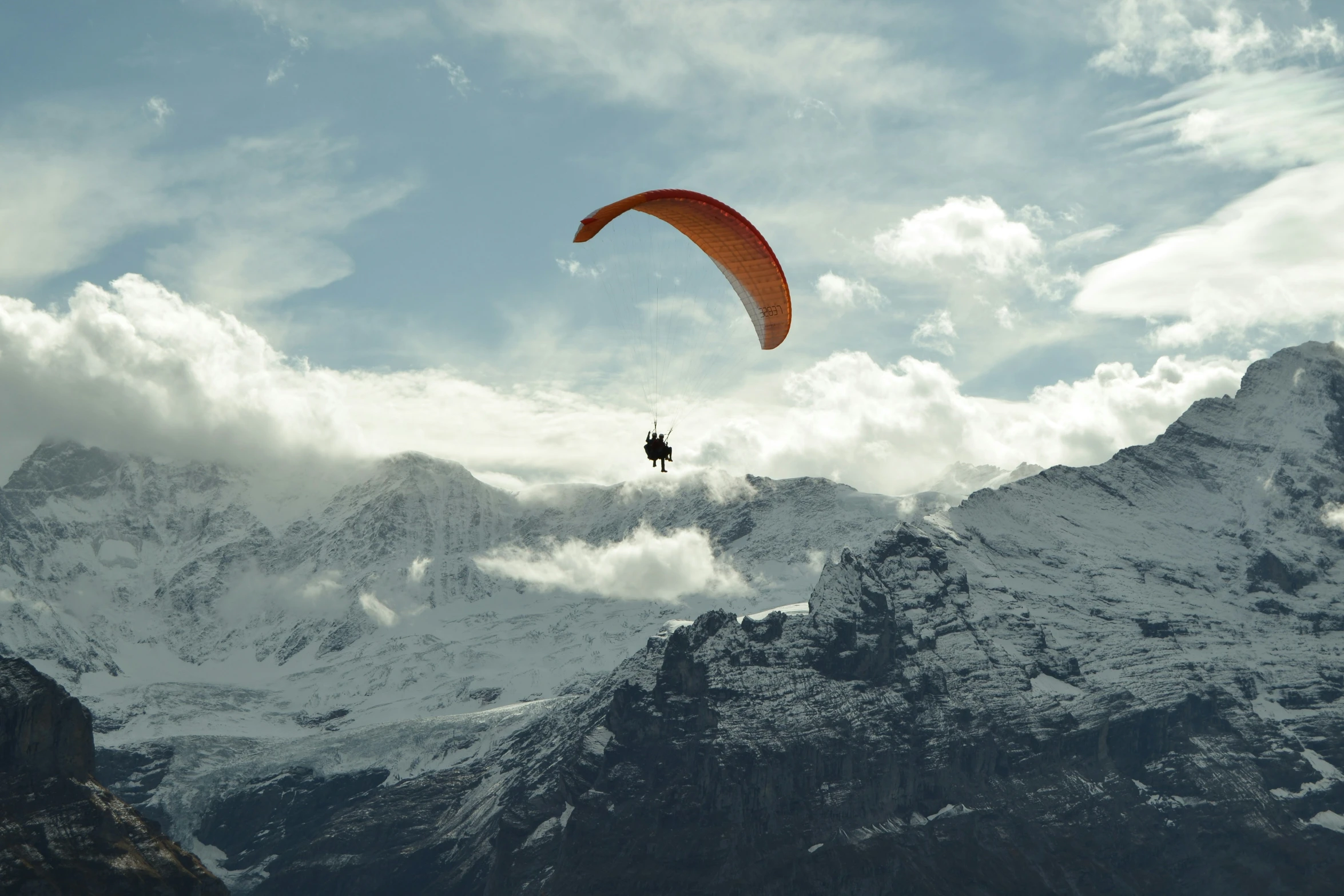 a parasailer is in the middle of a large mountain