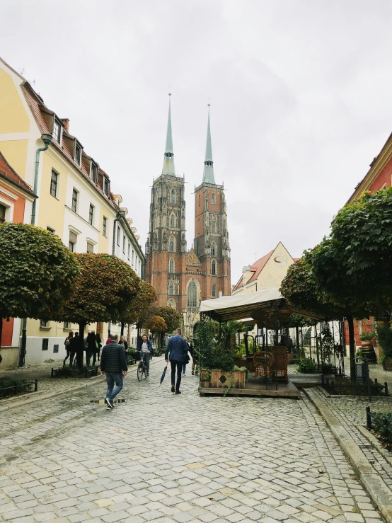 people walking down a street next to a large cathedral