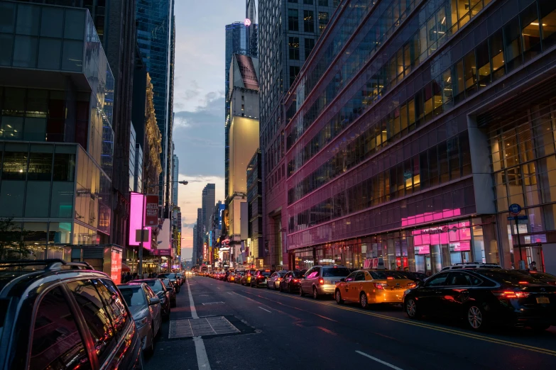 an empty city street with very tall buildings and cars