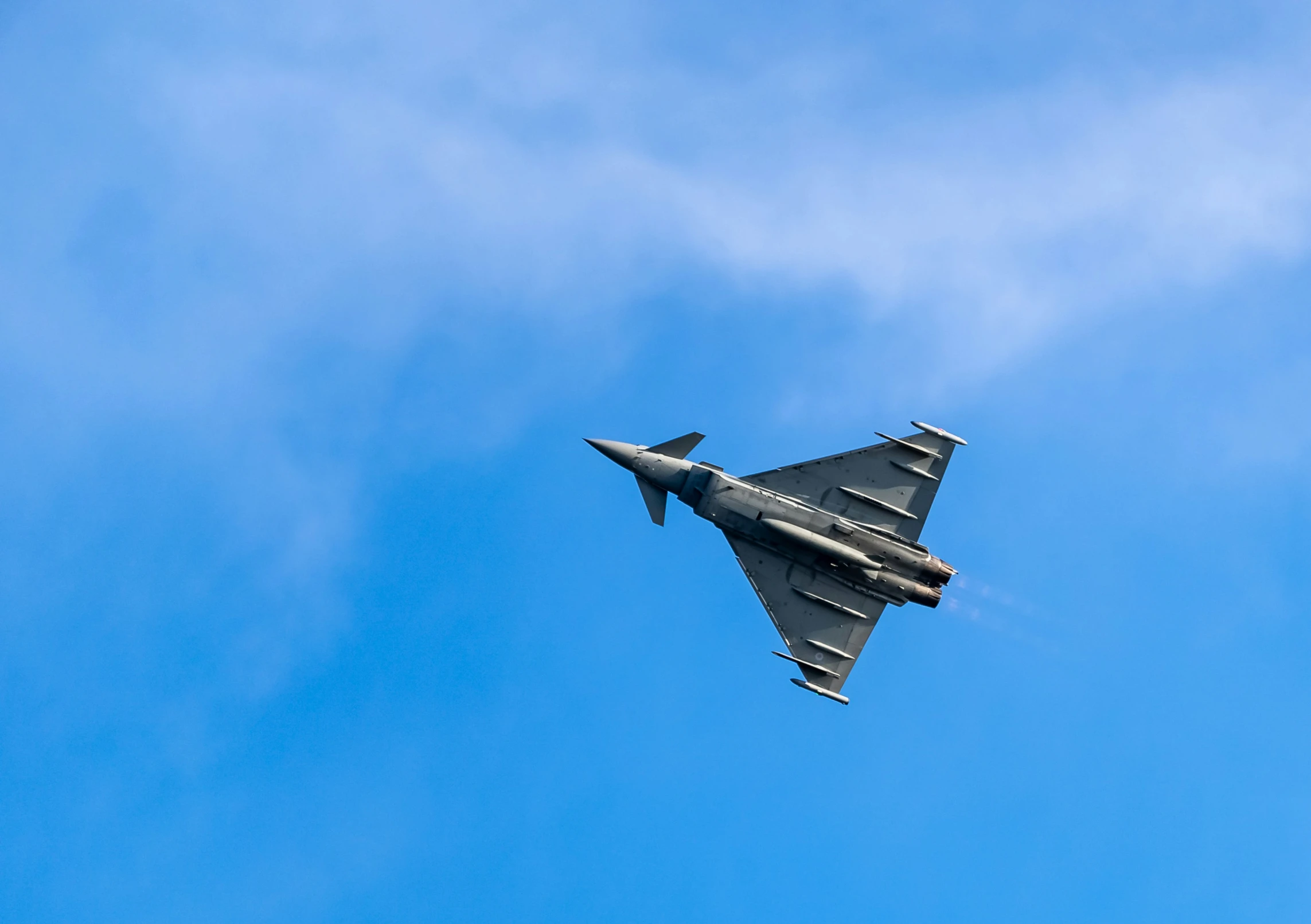 a military jet is flying through the sky