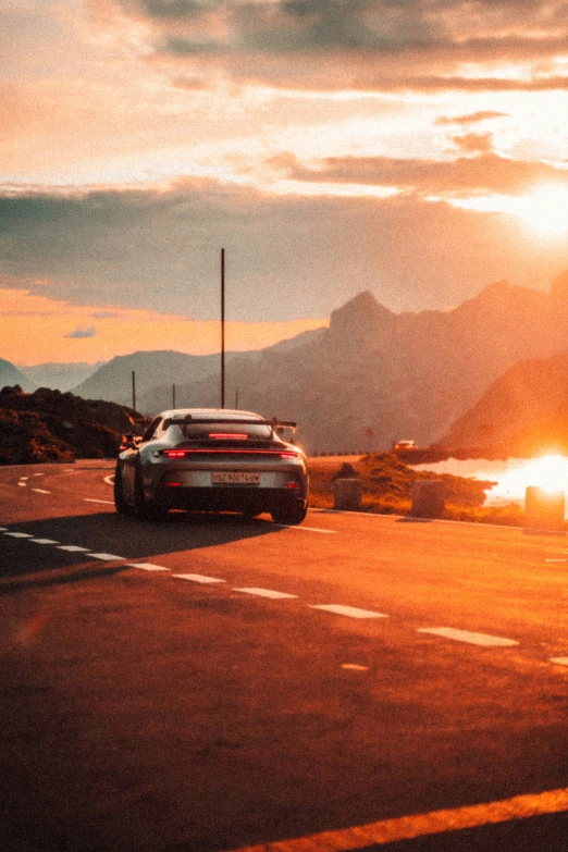 a car driving through the sun going down