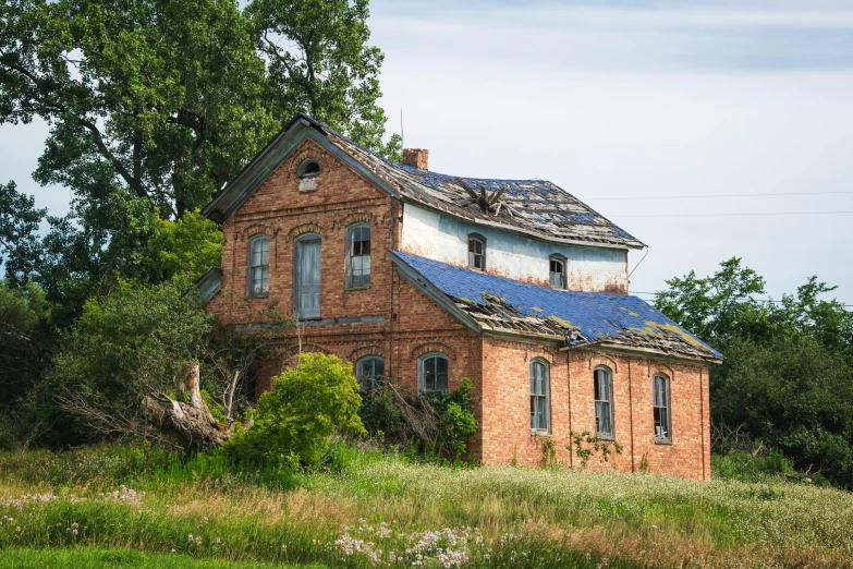 an old, run down building with a broken roof sitting in a field of flowers