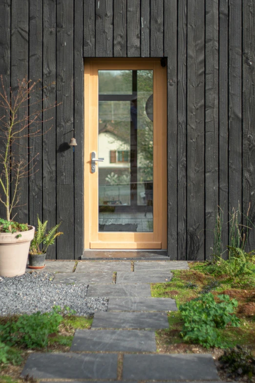 a building with black wood and yellow glass door