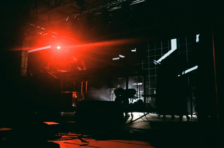 a band performs on stage while red light shines on the walls