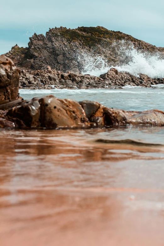 the water is rushing over the rocky beach