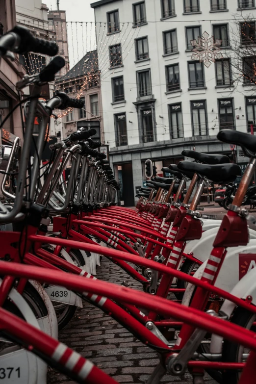 many bicycles are lined up on the brick street