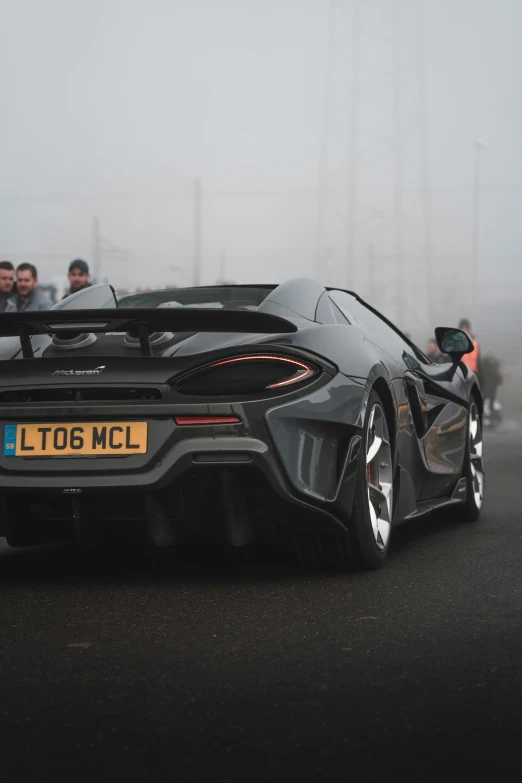 a supercar is driving around the track on a cloudy day