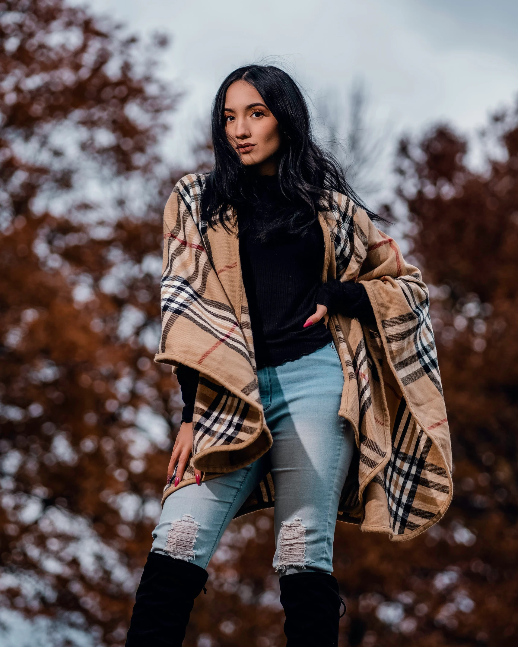 a woman wearing boots and jacket standing outside