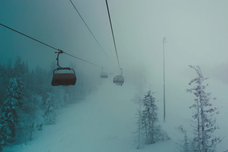 a ski lift going up in the air over the snow