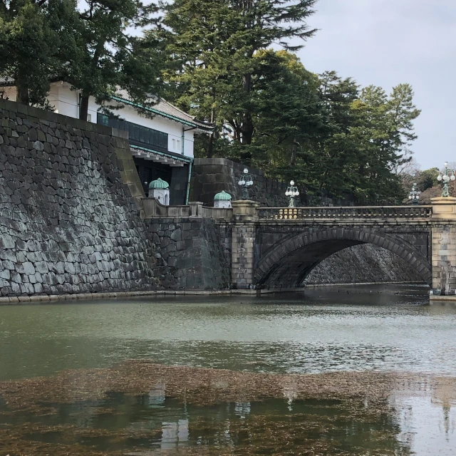 an old stone bridge over a river in a city