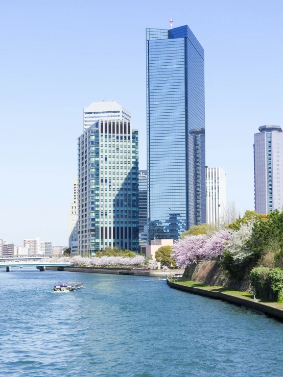 people on small boats are floating on a river near some tall buildings