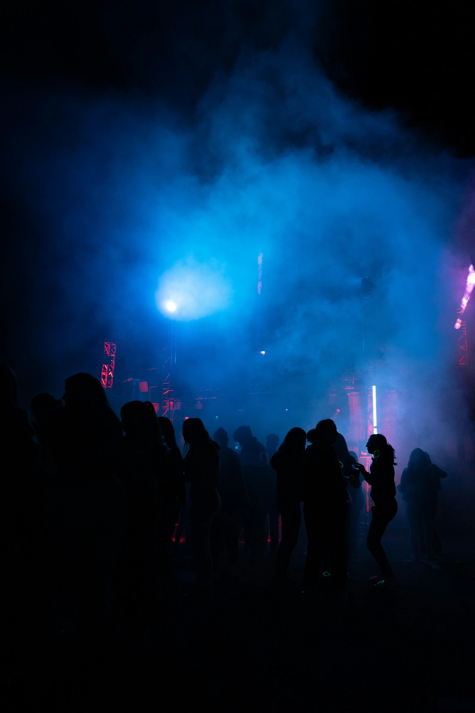 several people walking through a stage lighting up at night