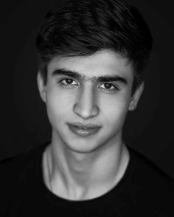 a young man looking at the camera with black background