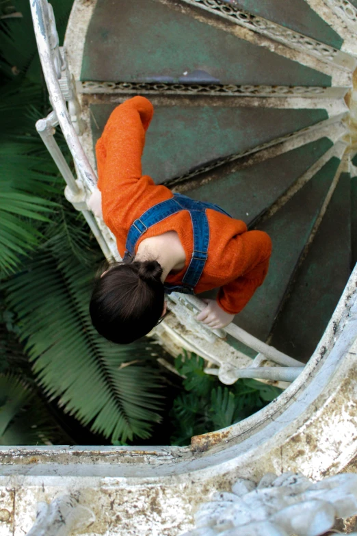 a child climbing the top of a wooden stair case