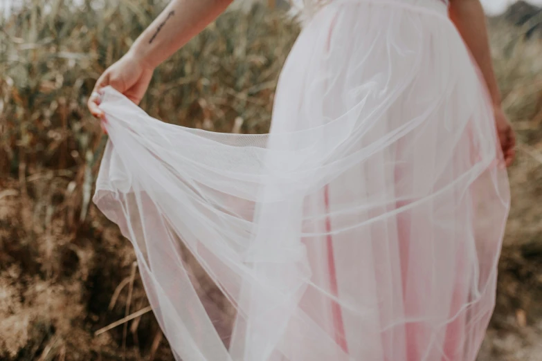 the dress is sheer white in color and the dress also has pink ribbon