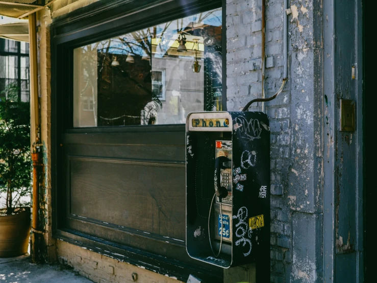 an old phone sitting outside of a store