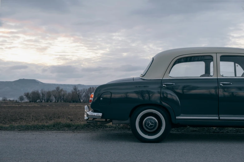 an old fashion black and tan car parked on the street