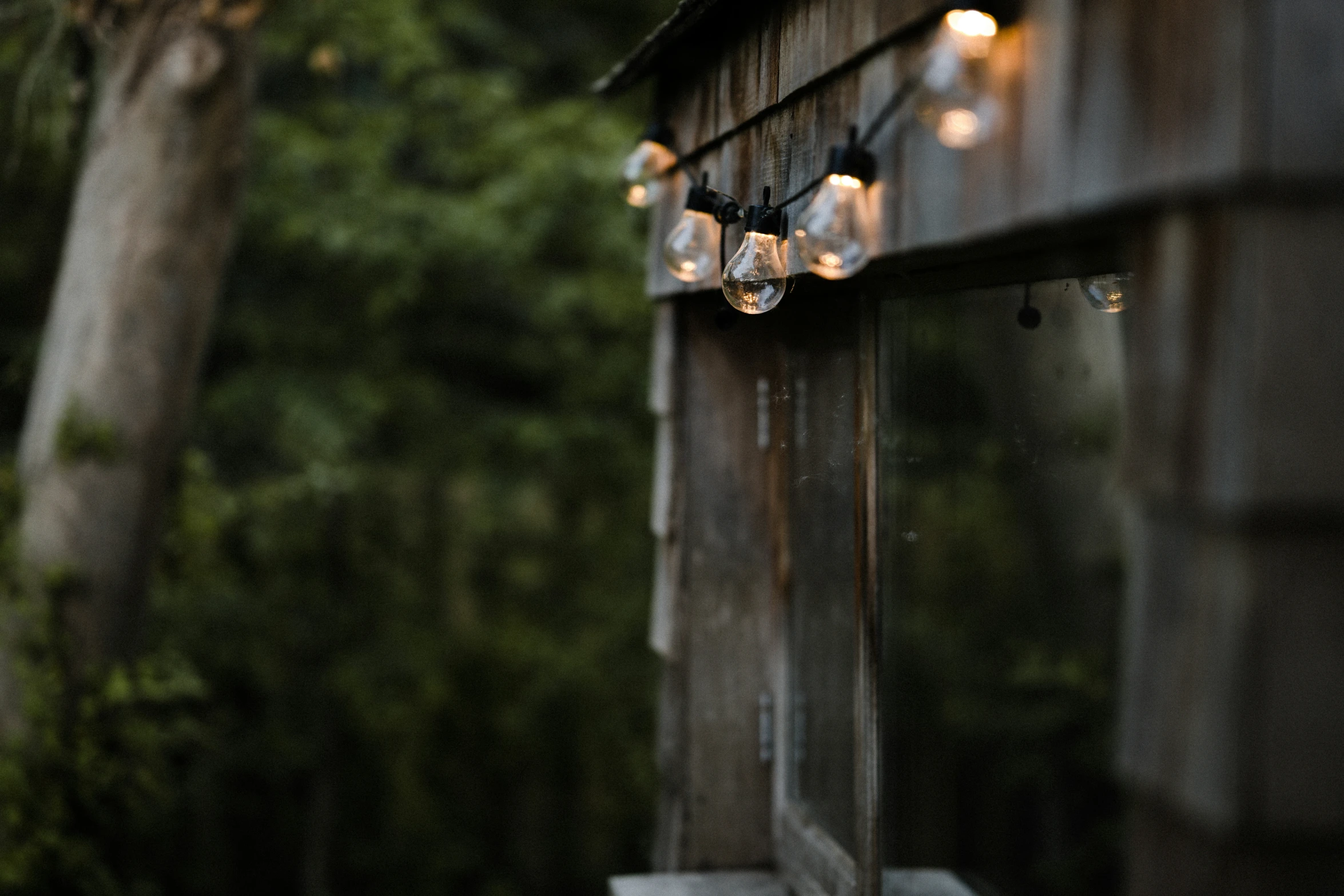 a light on a wooden structure next to some trees