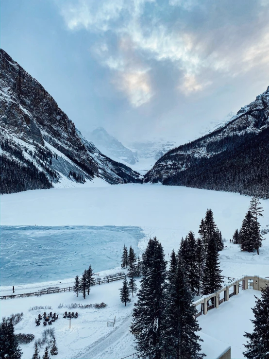 some snow trees and a hill and water