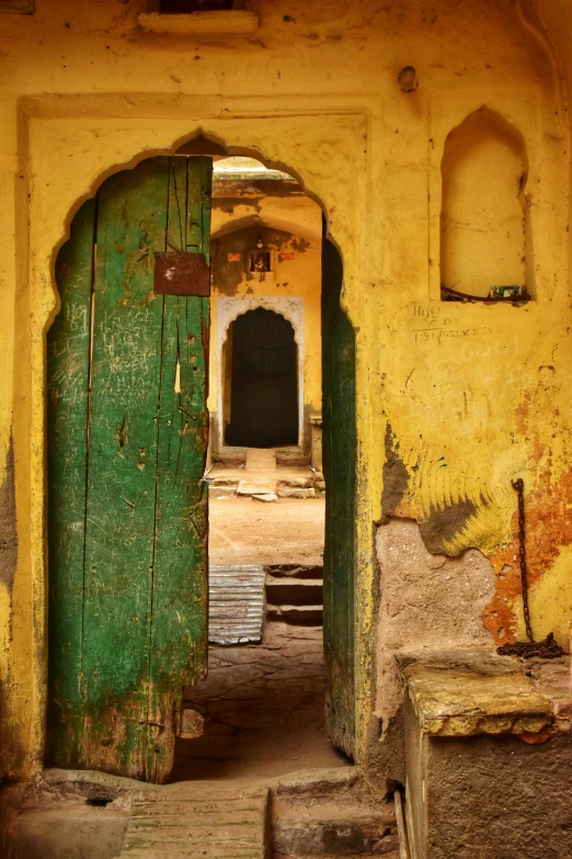 a green doorway opened onto a yellow building