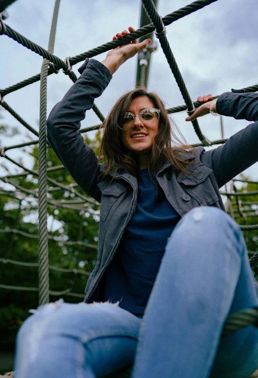 woman is sitting down on a roped area at the top of a hill