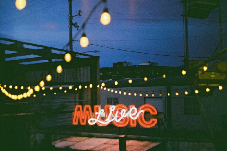 large sign with lights strung around it on a dark night