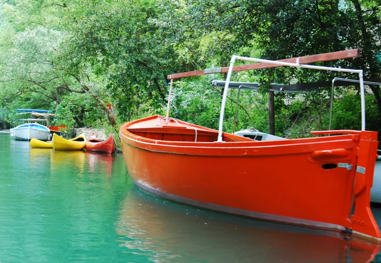 four different colored canoes lined up on the water
