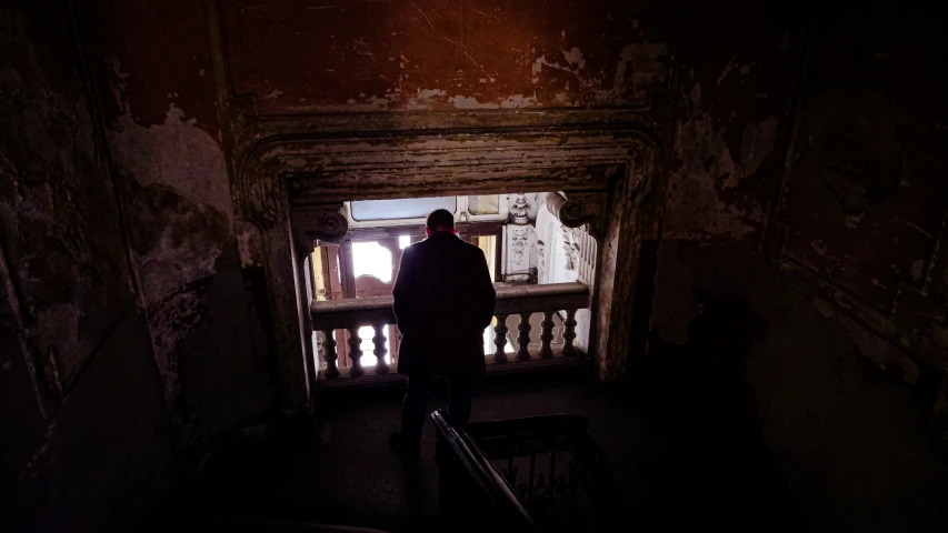 a person looking at the floor of a room that contains multiple windows