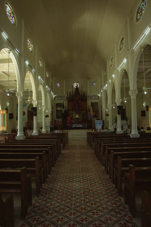 the inside of an church with pews and stained glass windows