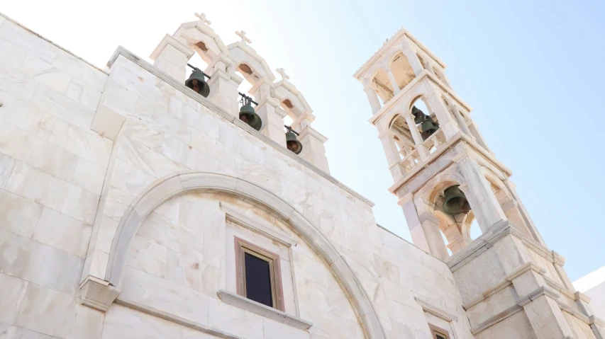 two bells are on the top of the tower of a building