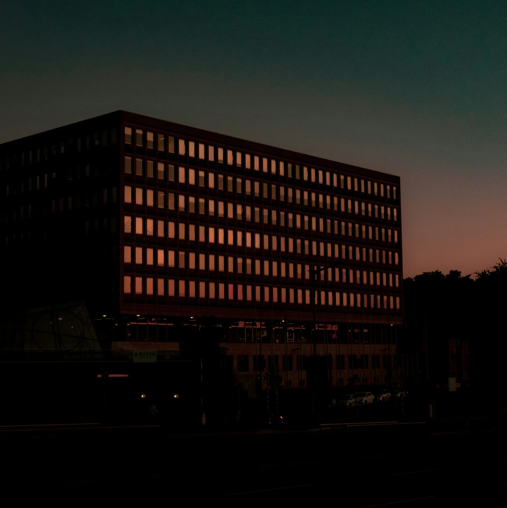 a building at dusk with a dark sky in the background