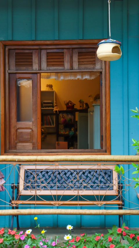 flowers sit in the grass near a window with wood trim