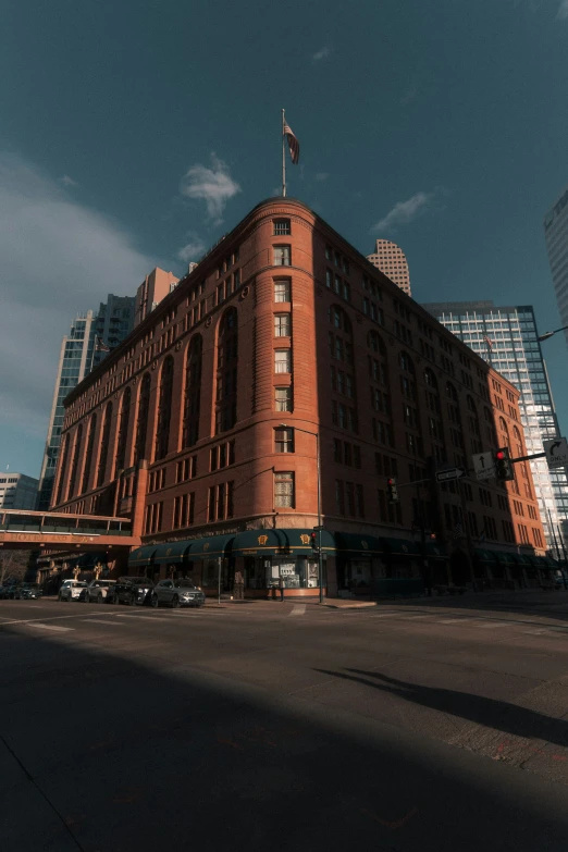 an old brown brick building with tall buildings in the background