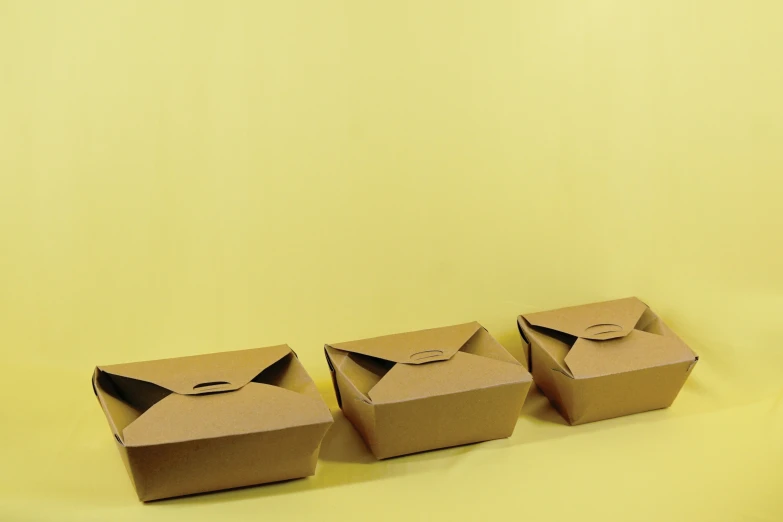 three boxes are sitting in front of a plain yellow backdrop