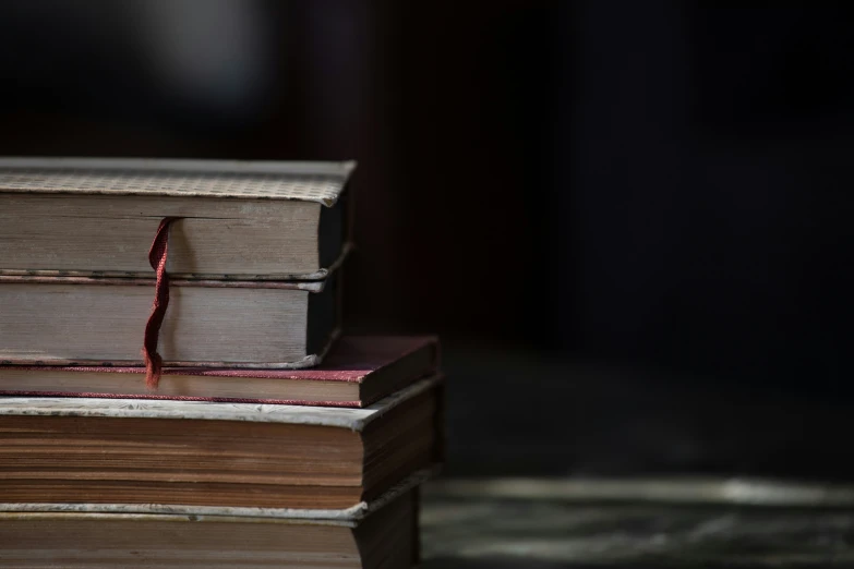 three books sit on top of each other in the dark