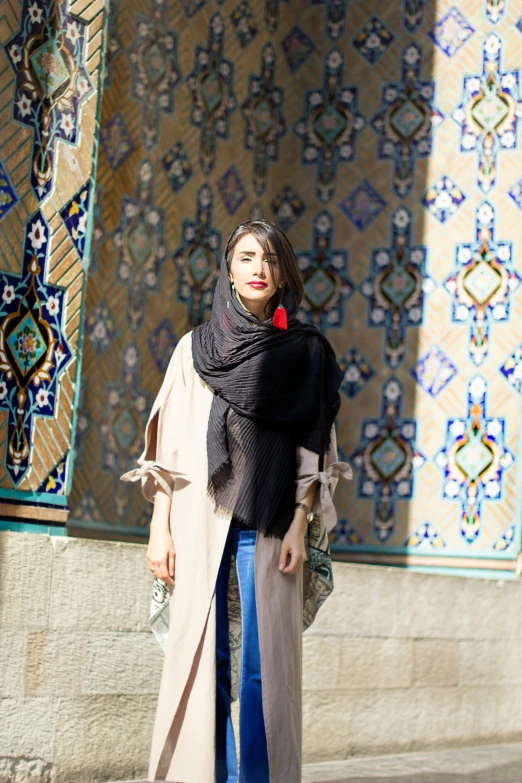 a woman is standing in front of some colorful tiles