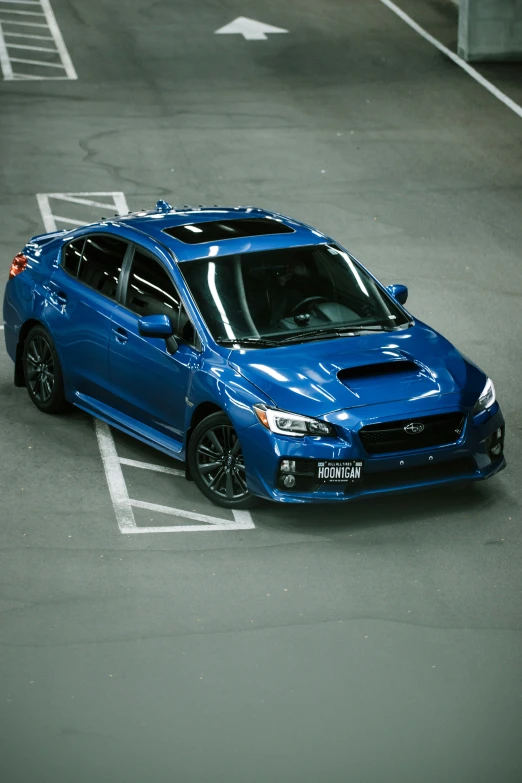 a blue subaru wrd parked in an empty parking lot