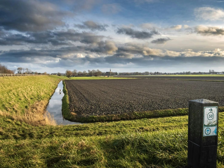 a large field with a small stream running through it