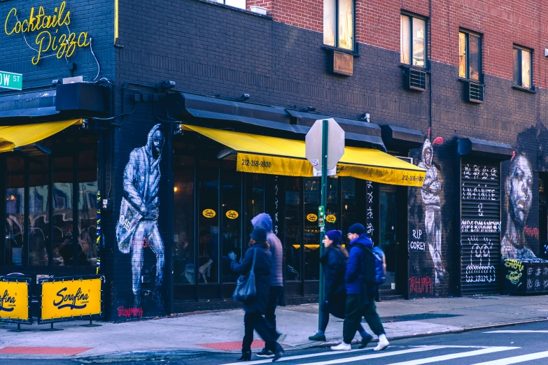 a group of people walk down the street near some buildings