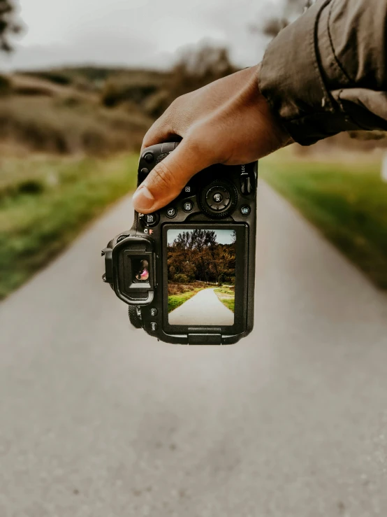 someone taking a picture of an asphalt road with a camera